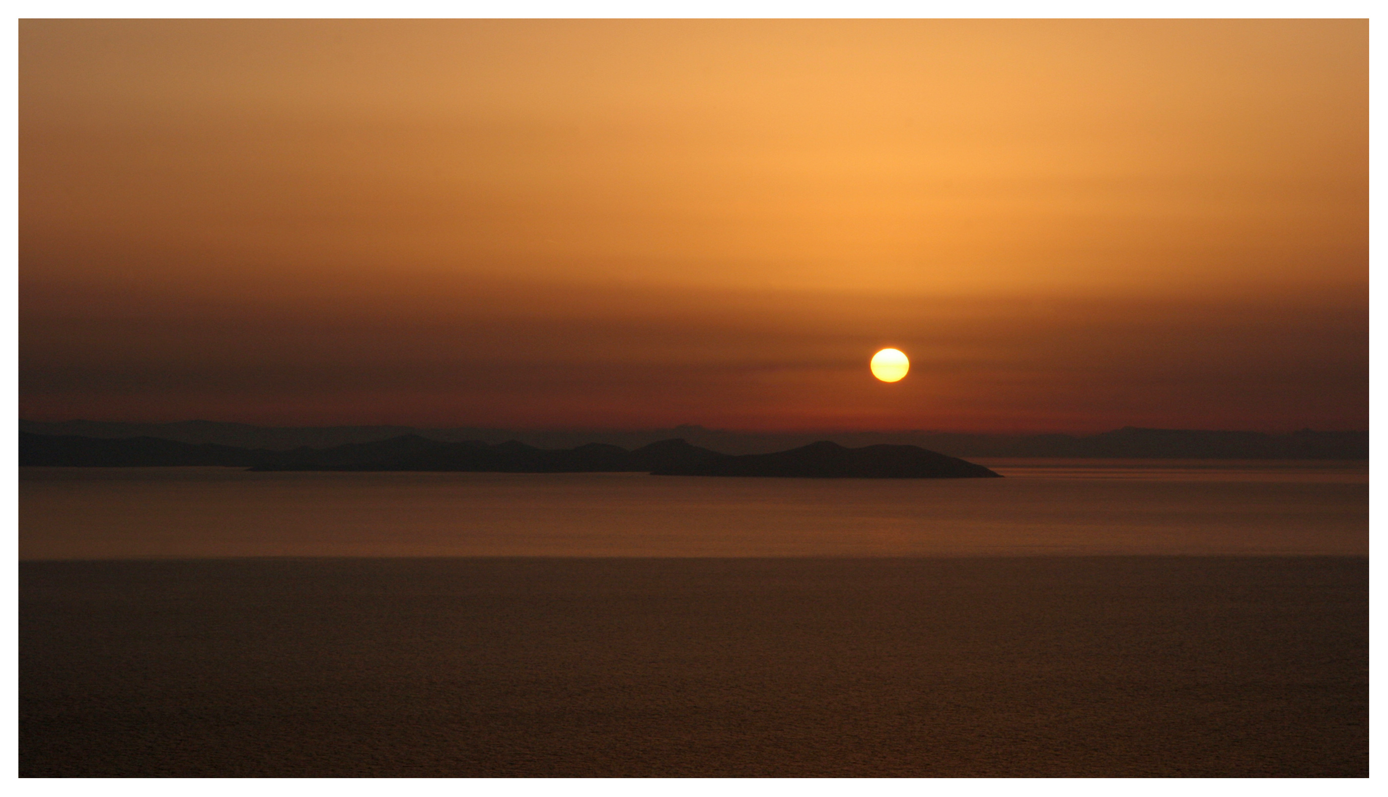 Yachting photography, Greek islands, Cyclades. Glorious sunrise at Sifnos looking eastwards to Antiparos and Paros