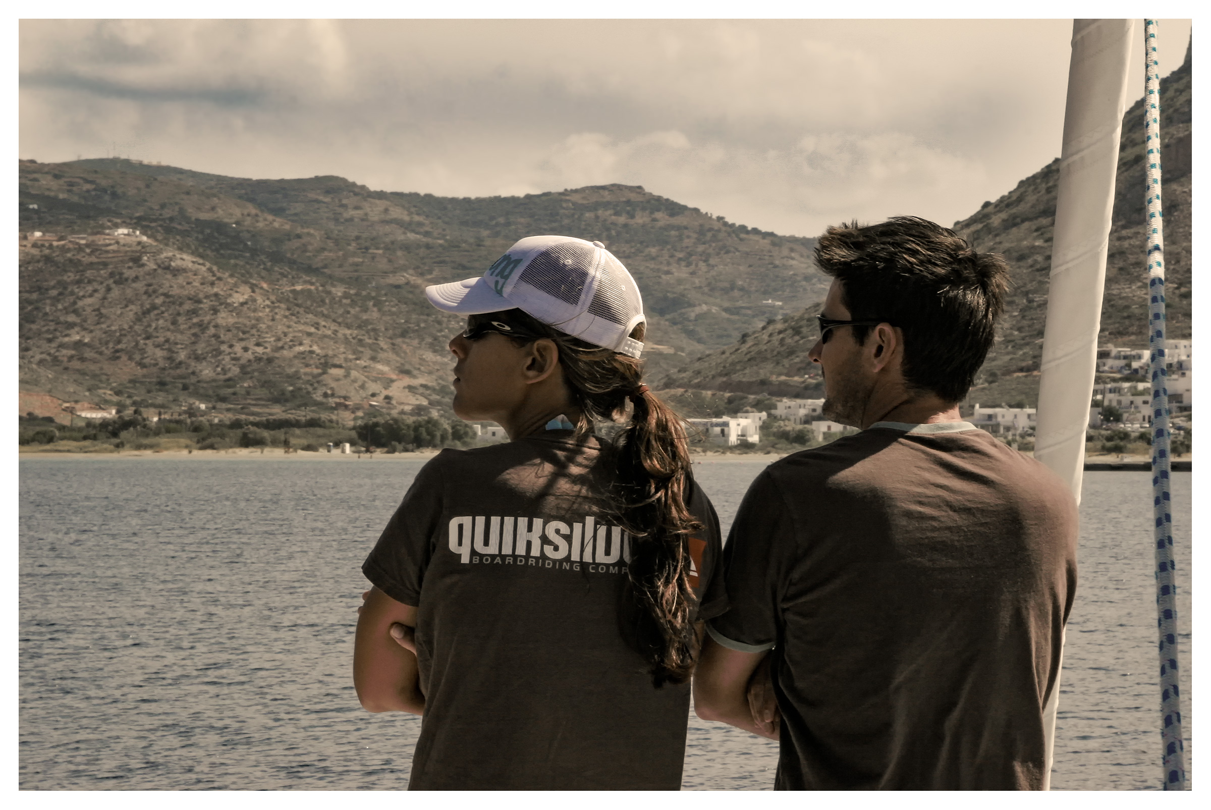Yachting photography: couple taking in the views from a yacht arriving at Sifnos, Cyclades, Greece