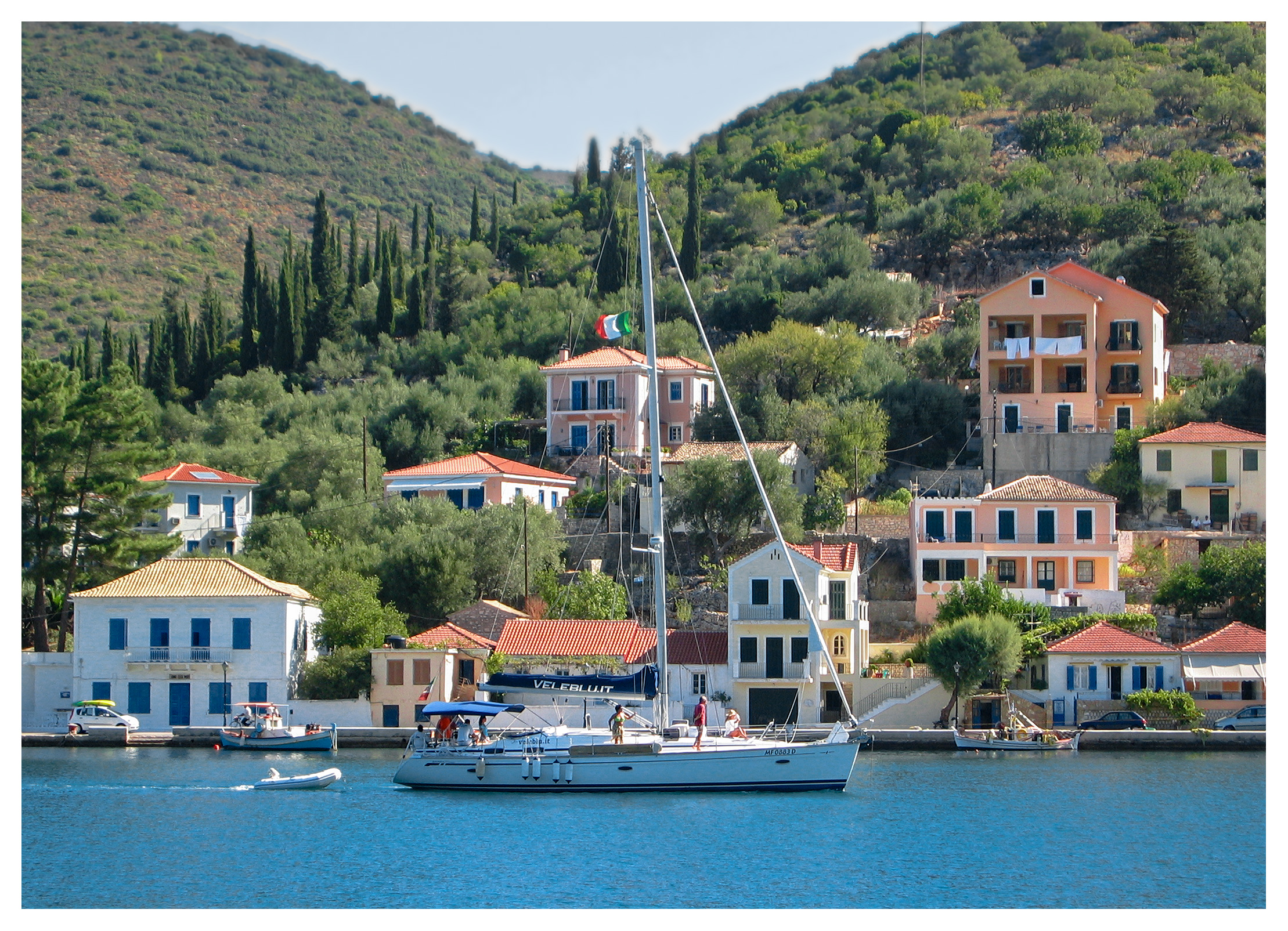 Yachting photography: A yacht passing by the seafront at Vathi town, Ithaka, Greece