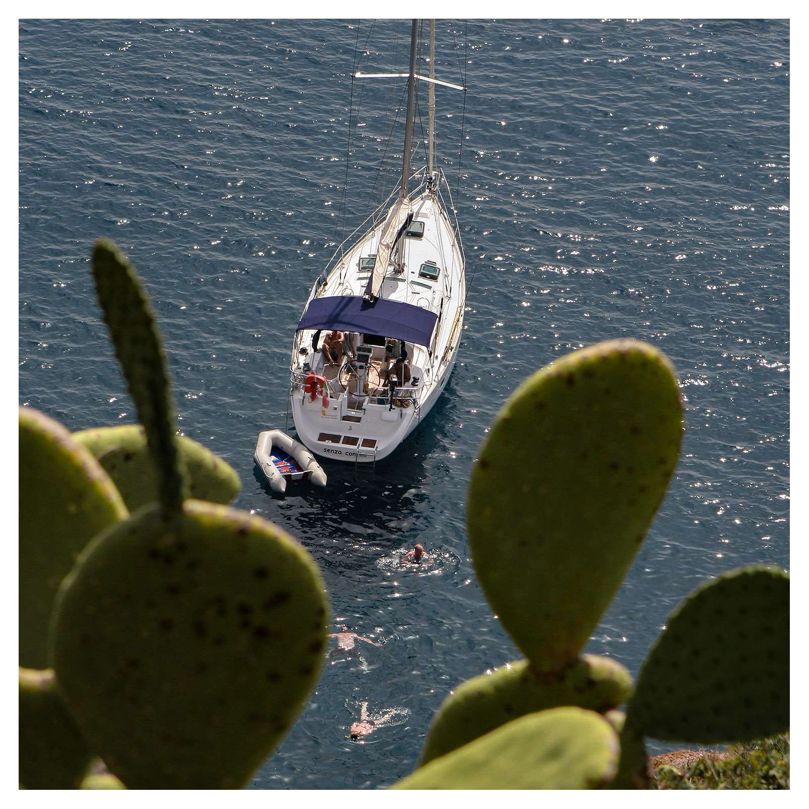 People swimming next to a sailing yacht anchored off Capo Milazzese, Panarea, Aeolian islands, Sicily